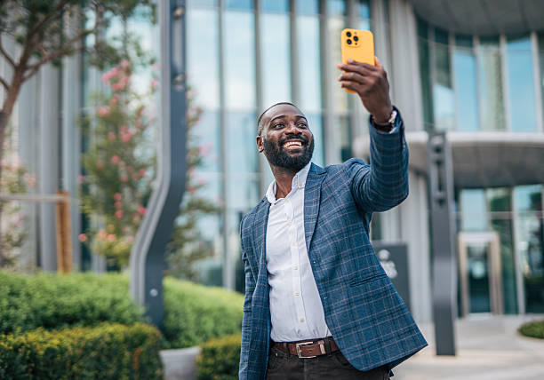 istock Smiling businessman taking a selfie outside office building 2231481527