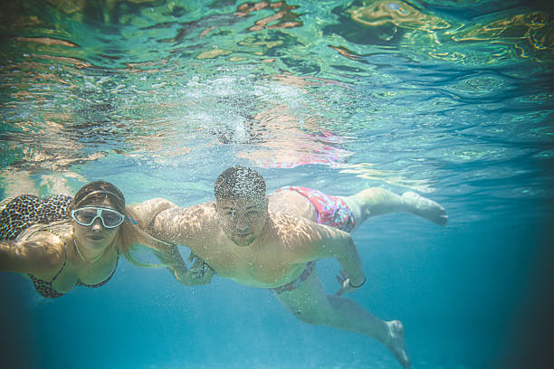 istock Joyful Couple Holding Each Other's Hands While Exploring Clear Blue Waters 2231481939
