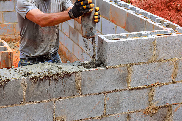 istock Construction worker laying concrete blocks at building site during daylight hours in residential area 2231485325