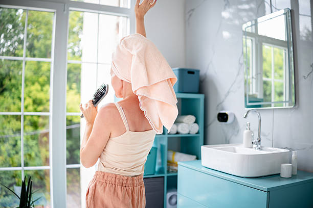 Selective focus on sponge and white towel are place on table at home. Liquid soap or shampoo bottle, talc powder bottle and hair brush are near. Baby shower accessories concept. Top view