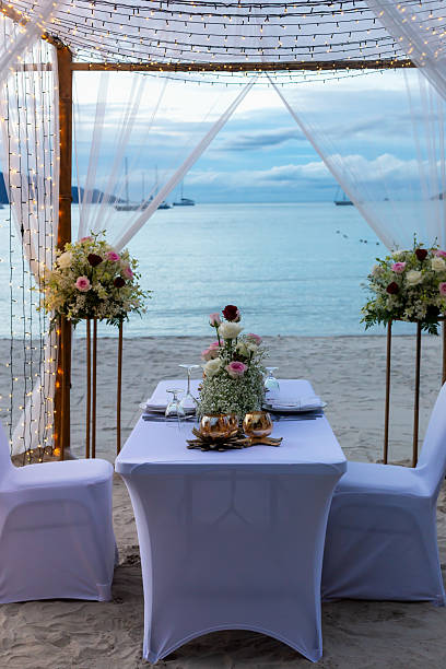 istock Romantic beachside dining setup with elegant decor and floral arrangements at sunset 2231489867