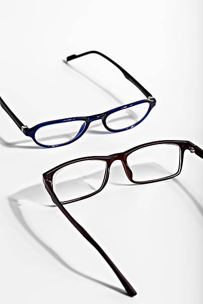 Stylish eyeglasses in various colors displayed on clean white background with shadows