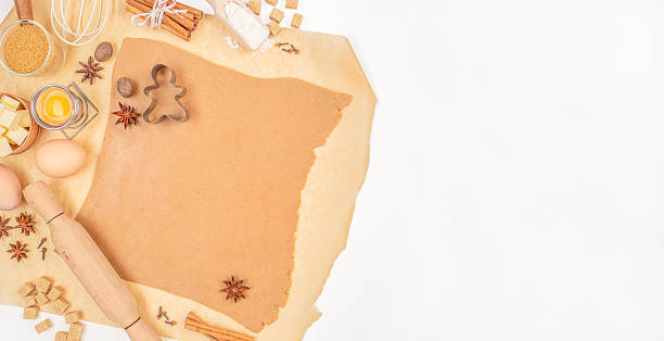 istock Gingerbread dough with cookie cutter and baking ingredients on parchment paper. Long banner format. top view. copy space 2231495590