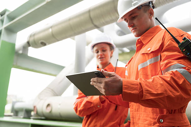 istock Petroleum Refinery. Oil refinery. Gas pipeline network system. Petrochemical engineer working, discussing and inspecting gas pipeline, valves and mechanisms deliver natural gas 2231500558