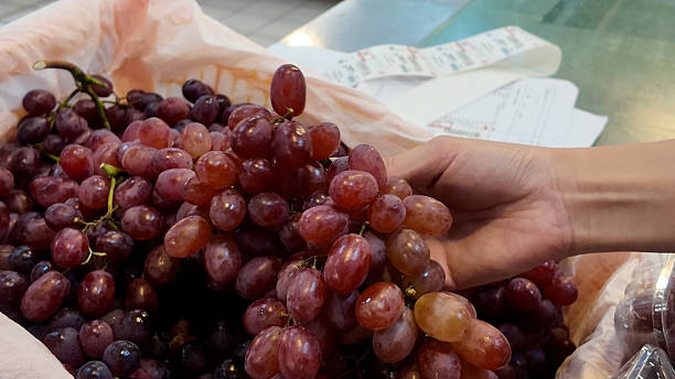 istock A hand is holding a bunch of grapes 2231501926