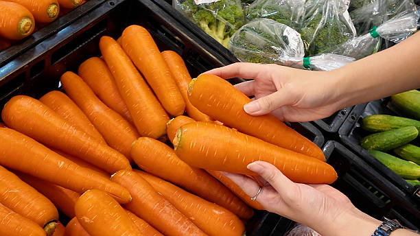 istock A woman is holding a carrot in her hand 2231502117