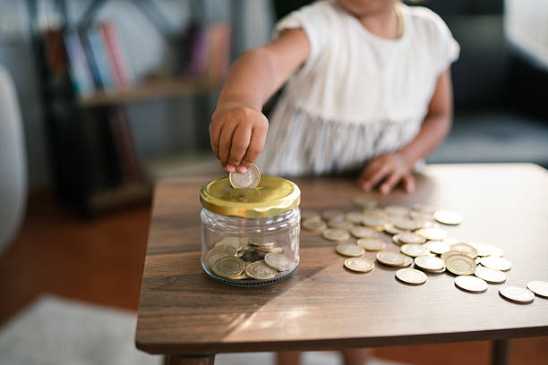 istock Child saving money in a jar for future investment 2231506716