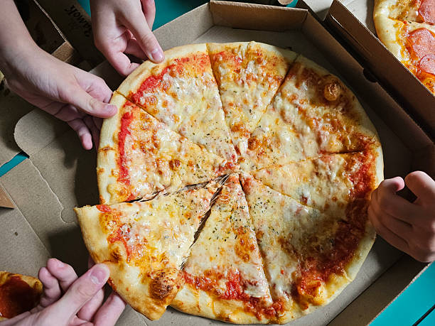 istock Friends sharing a delicious cheese pizza from a pizza box 2231516061