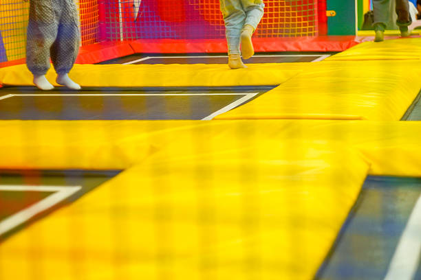 Black and white shot of young male athlete doing somersault in gym