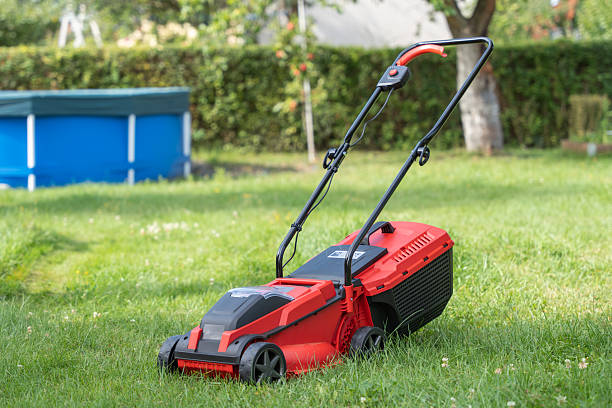 istock A red lawn mower stands on green grass in a backyard. 2231525747