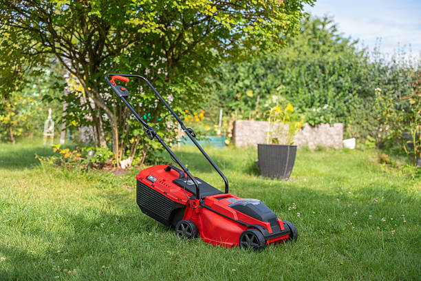 istock A red lawn mower on a sunny lawn near a tree. 2231526092
