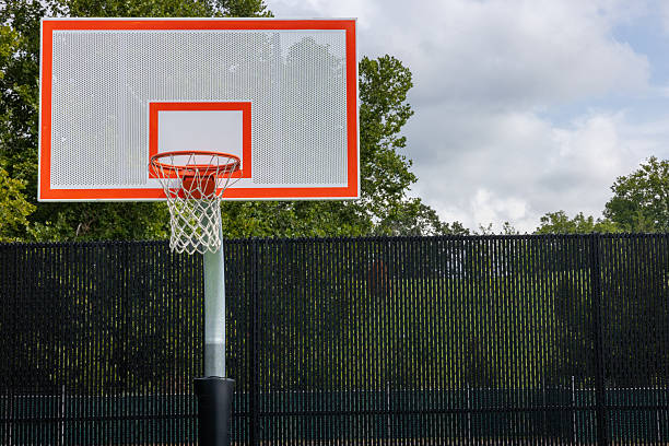 Outdoor basketball court in a park where people can enjoy playing and recreational activities.