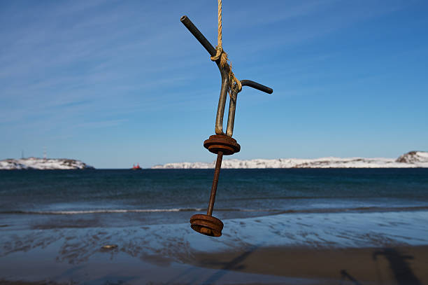 An intriguing and unusual object hangs high above the beach, creating a striking contrast with the serene ocean view