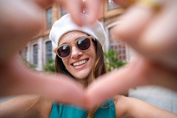 istock Young woman making heart shape with hands and smiling at camera 2231532373