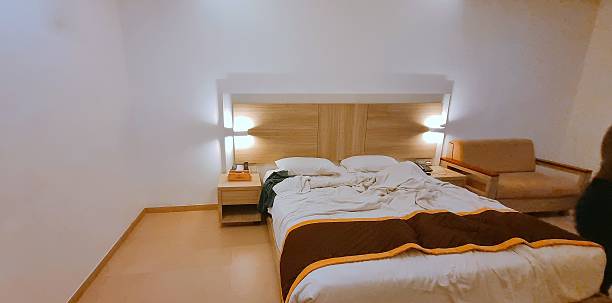 High quality premium Cozy hotel room interior with a comfortable double bed, warm lighting, and minimalist modern design. Perfect for travel, hospitality, and accommodation themes