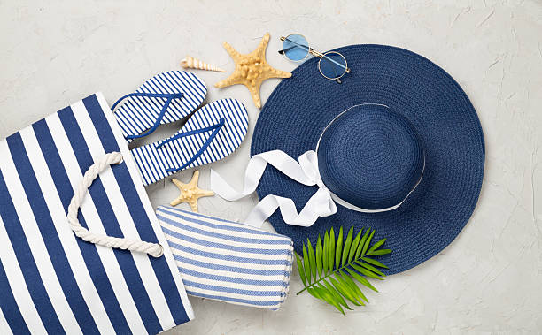 istock Blue beach bag with summer accessories on concrete background, top view 2231540048
