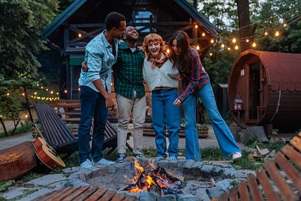 istock Group of people standing by a fire pit and laughing 2231540886