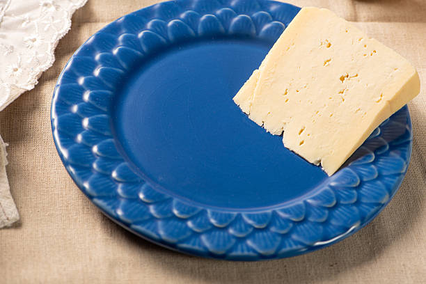Table with rustic utensils and a semi-cured cheese from Brazil, selective focus.