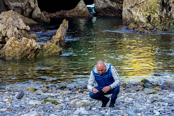 A man searches for fossils in the rocks, Cala en Castro-Urdiales - Cantabria - Spain