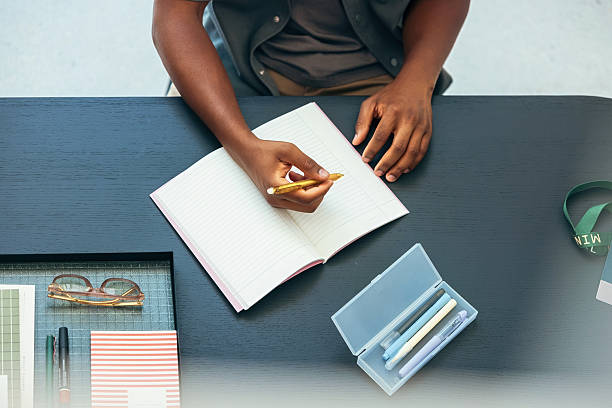 istock Person Writing Notes in a Notebook on a Organized Desk 2231544624