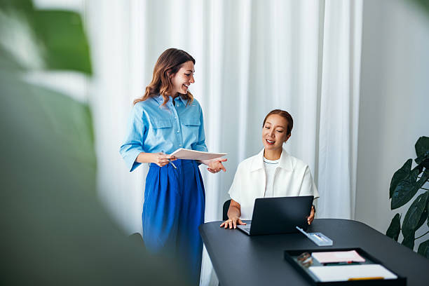 Professional Women Collaborating on Work at a Modern Office Desk