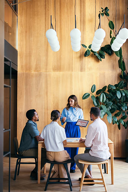Team Collaborates in Modern Office Setting With Wooden Design and Greenery