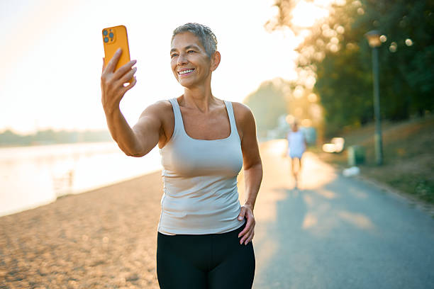 istock Mature woman taking a selfie while exercising outdoors 2231546112