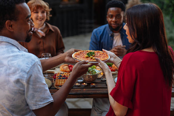 istock Group of people having pizza at a backyard dinner party 2231547261