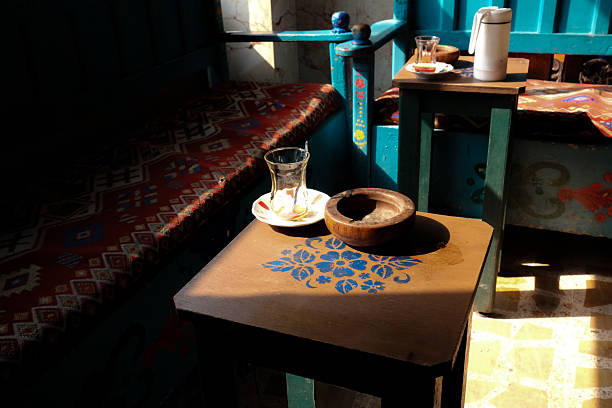 Cozy cafe setting with empty tea glass and ashtray on a table.