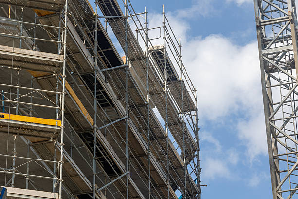 istock Scaffolding and crane reaching for the sky during building construction 2231555127