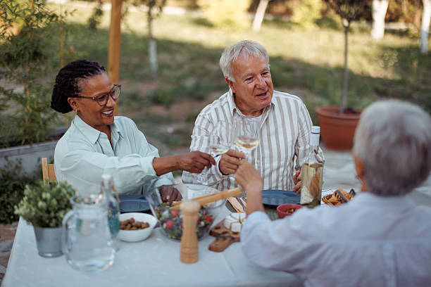 istock Three senior friends enjoying dinner party outdoors 2231561021