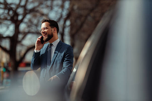 istock Businessman Talking on Phone by Car 2231565567