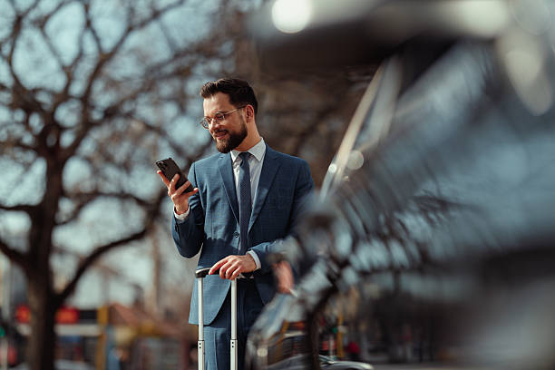 istock Businessman With Suitcase Checking Phone 2231565578