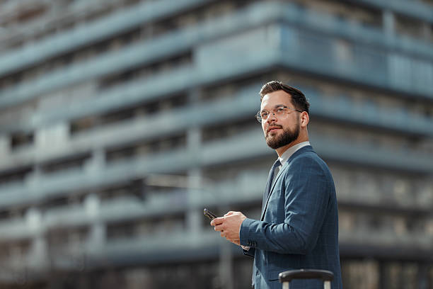 istock Smiling Businessman Using Smartphone Outdoors 2231565582