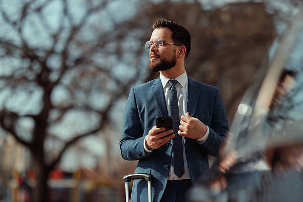 istock Businessman With Suitcase Checking Phone 2231569262