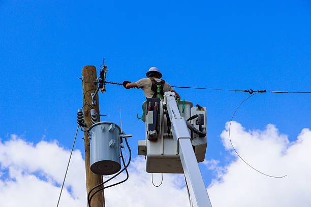 istock Utility worker repairs electrical lines using cherry picker on sunny day in rural area 2231571044