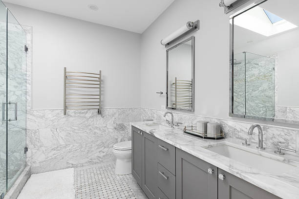 istock A bathroom with marble tile and countertop and a grey cabinet. 2231578643