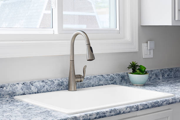 istock A kitchen faucet detail on a blue countertop. 2231579457