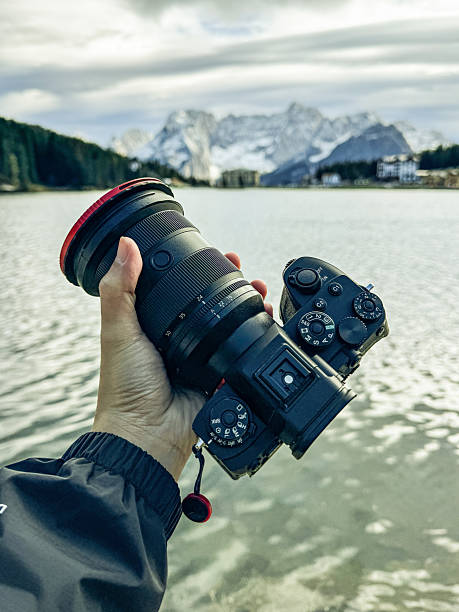 istock Hands holding full frame camera with nature snow mountain view background. 2231581916