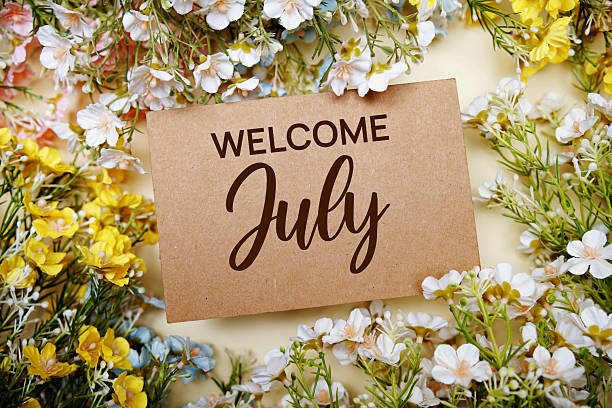 istock Welcome July text message with flower decoration on yellow background 2231585672
