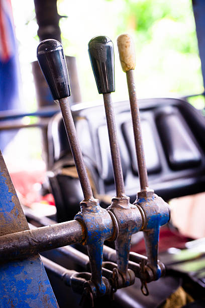 This image captures an abstract close-up view of a tractor control lever. The blurred and vibrant blue-green hues create a sense of depth and mystery.