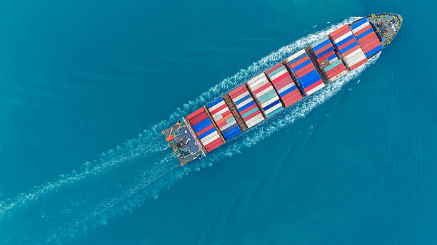 istock Aerial of cargo ship carrying container and running verry fast for export cargo from cargo yard port to other ocean concept smart freight shipping ship top view 2231587116