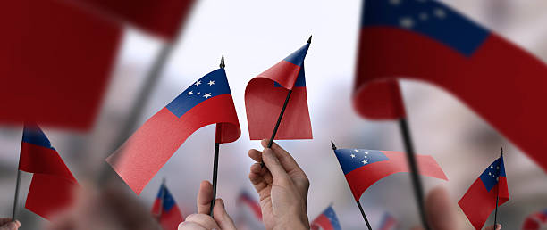 istock Samoa flags in their hands on a blurred urban background 2231587435