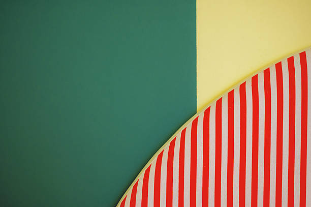 Abstract close-up of interior design showing geometric shapes and bold colors with a striped curve against a green and yellow wall background.