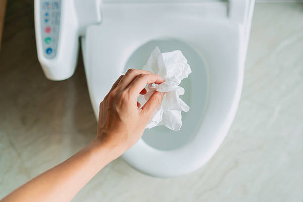 istock A hand is throwing tissue paper into the toilet bowl 2231593219