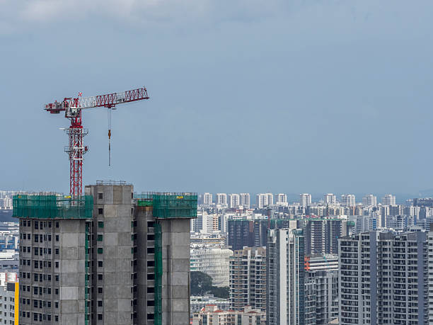 A wide shot of a construction crane in Singapore housing building site with blue sky and copy space