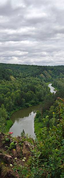istock Idyllic River Bend Through Verdant Forest Under Cloudy Sky, Perfect for Outdoor Adventures 2231595347