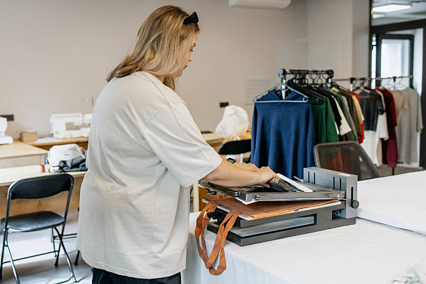 istock Woman Printing on Fabric with Silk Screen Machine in Modern Workshop – DIY Textile Design Process 2231595907