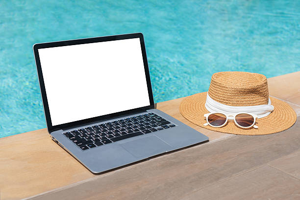 istock Computer with blank screen near swimming pool. Work from anywhere, summer concept. Copy space 2231603067