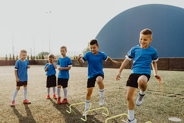 istock Group of boys jumping obstacles during training on soccer field 2231604817